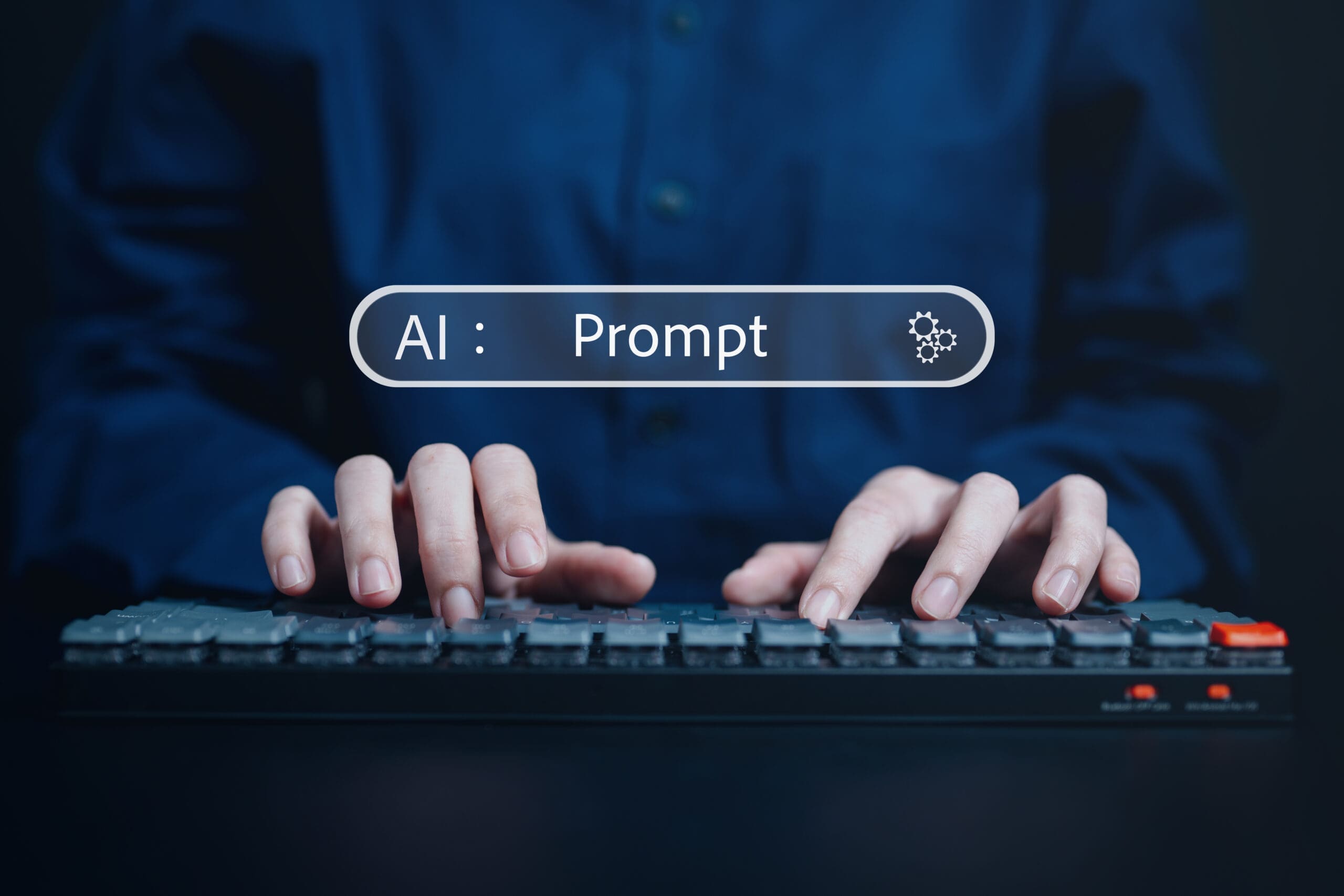 Hände tippen auf einer Tastatur, im Hintergrund ein Eingabefeld mit dem Text "AI: Prompt"